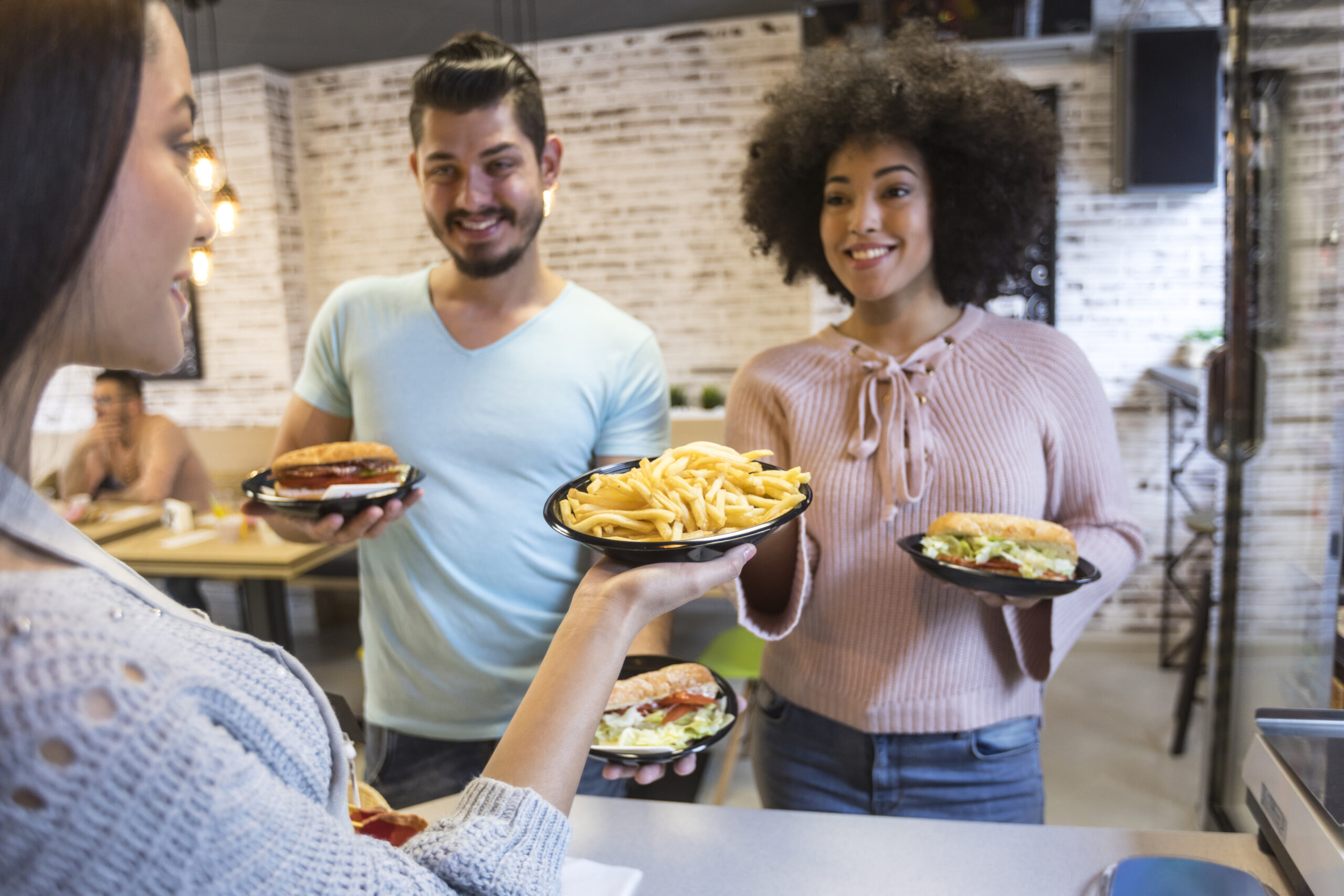 Couple-in-fast-food-restaurant-buying-burgers-937358382_6720x4480