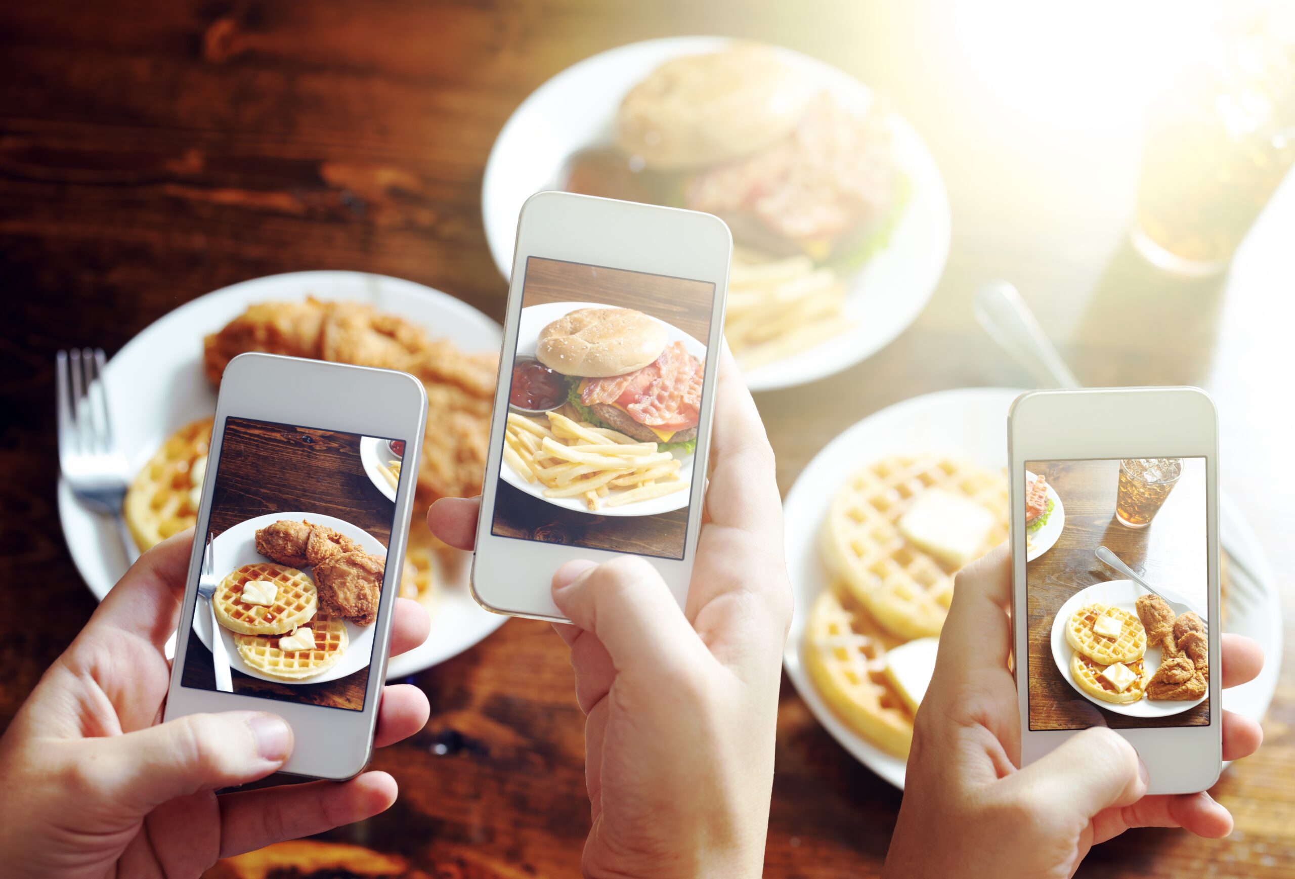 friends-taking-photos-of-food-with-smart-phones-508631655_7555x5130